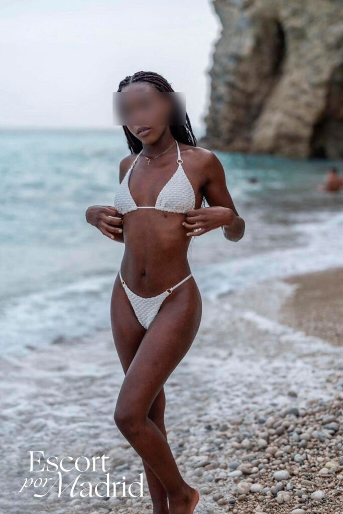 Escort negra posa en la playa con bikini blanco muy sexy. Zahara